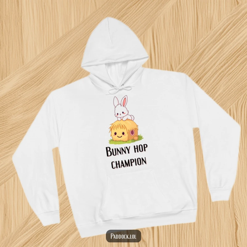 Funny bunny hoodie showing a fluffy bunny hopping over a tiny, smiling hay bale, radiating cheerfulness and playful energy.